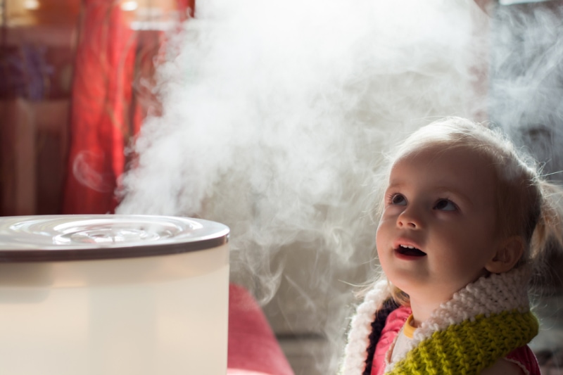 Little baby playing with humidifier.